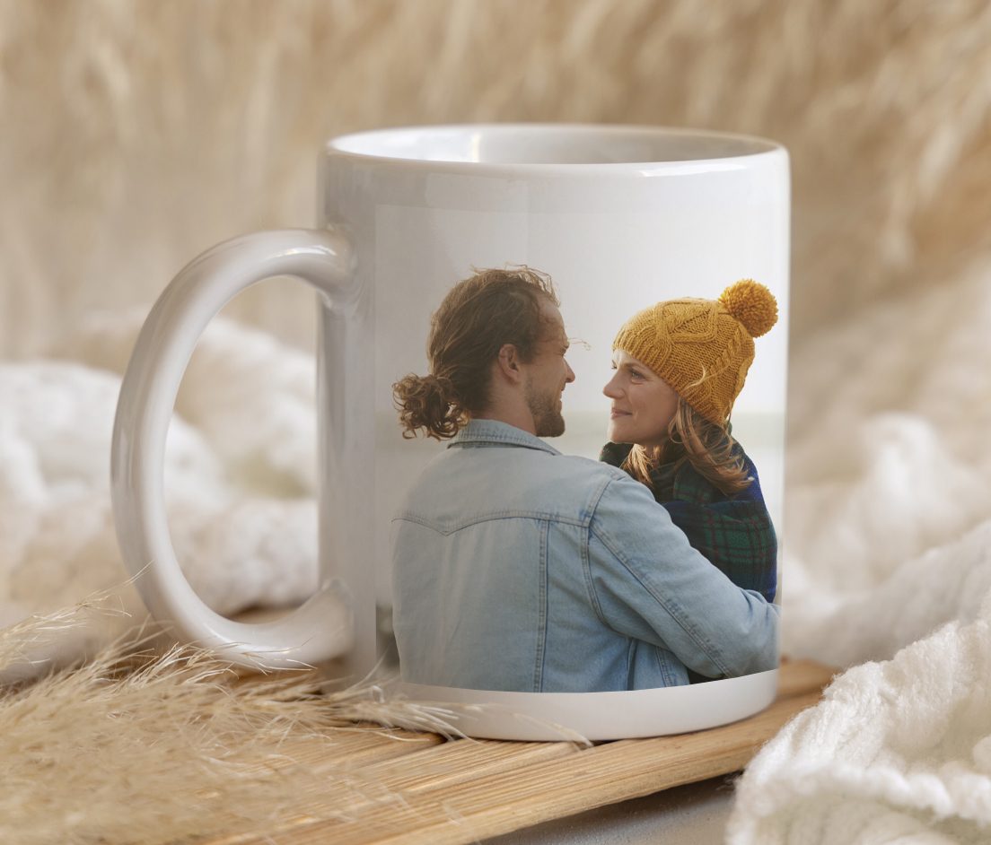 Canvas print of couple hugging with a surfbaord, a white mug with 'World's Best Dog' text and a picture of a person with a dog, half of a photobook of two women hugging